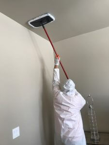 mold removal technician finishing a ceiling